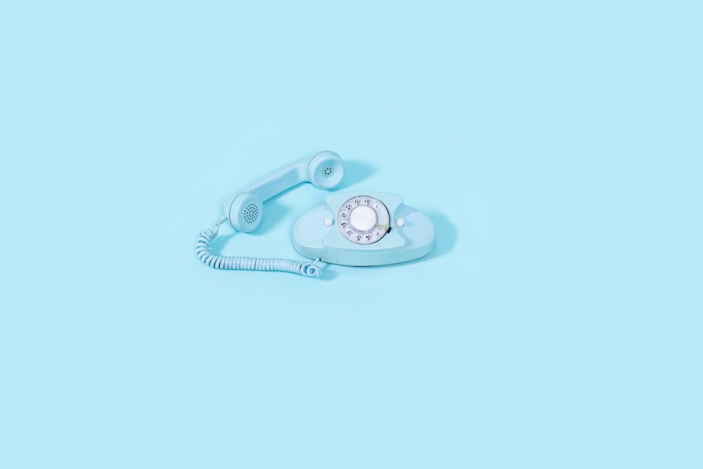 blue-vintage-rotary-phone-on-bright-blue-background