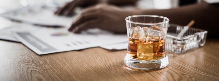 Businessman drinking from stress at workplace